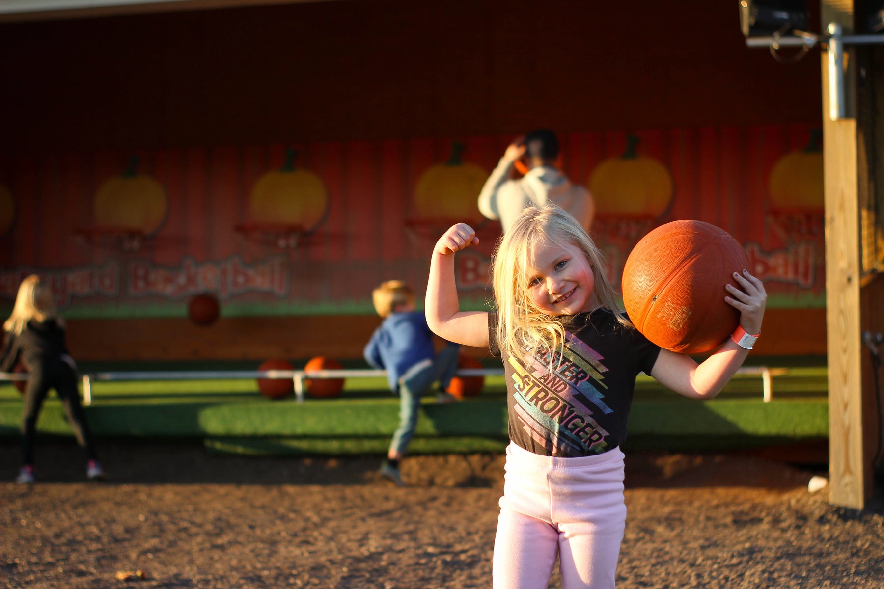young girl holding basketball and strong arm